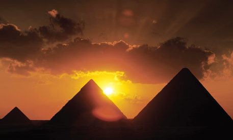 The sun sets behind the Pyramids, one of the most famous monuments in Egypt.